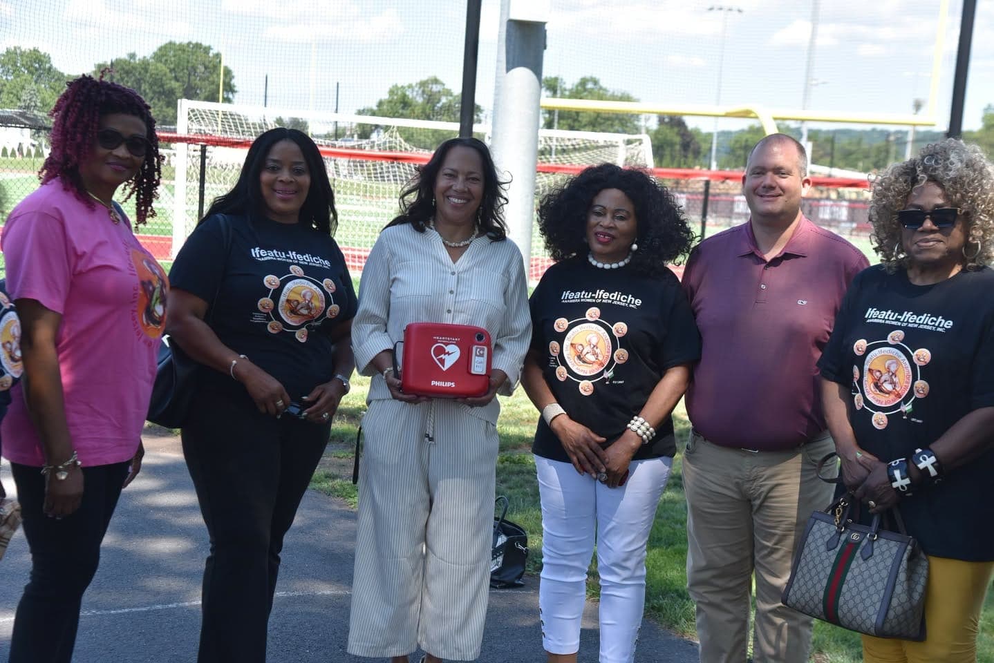 Representatives of the donating organization gather with township officials and the newly donated AED.